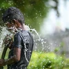 Trẻ em chơi đùa với nước để giải nhiệt trong ngày nắng nóng tại Ấn Độ, ngày 28/5. (Ảnh: AFP/TTXVN)