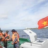 Tàu 471 tiến hành thủ tục bàn giao ngư dân Phan Kiệt cho đảo Song Tử Tây để đưa lên bờ điều trị. (Ảnh: TTXVN phát)