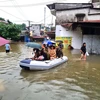 Cán bộ, chiến sỹ Công an tỉnh Hà Giang hỗ trợ di chuyển người và tài sản bị ngập sâu trong nước. (Ảnh: Nguyễn Lân/TTXVN phát)