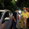 Cán bộ, chiến sỹ đội Cảnh sát Giao thông số 3 kiểm tra nồng độ cồn với tài xế ôtô trong đêm 12 và rạng sáng ngày 13/6. (Ảnh: Phạm Kiên/TTXVN)