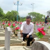 Chủ tịch Hội Nhà báo Việt Nam Lê Quốc Minh thắp hương tri ân các anh hùng liệt sỹ tại Nghĩa trang liệt sỹ Việt-Lào. (Ảnh: Duy Hưng/TTXVN)