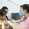 Nhân viên trạm Y tế Phường 6, Quận 8 tiêm vaccine phòng sởi cho trẻ. (Ảnh: Đinh Hằng/TTXVN)