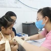 Nhân viên trạm Y tế Phường 6, Quận 8 tiêm vaccine phòng sởi cho trẻ. (Ảnh: Đinh Hằng/TTXVN)