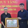 Chủ tịch UBND tỉnh Yên Bái Trần Huy Tuấn trao Bằng khen của Thủ tướng Chính phủ cho đại diện gia đình ông Nguyễn Văn Thi. (Ảnh: TTXVN phát)