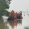 Các lực lượng chức năng di chuyển bằng thuyền hỗ trợ người dân vùng ngập lụt. (Ảnh: Thanh Thủy/TTXVN)