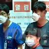 Nhân viên y tế Hàn Quốc bên các tấm biển cảnh báo về MERS tại trung tâm y tế quốc gia. (Ảnh: AFP/TTXVN)