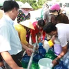 Người dân dùng tất cả các vật dụng có thể sử dụng được để lấy nước ở các xe bồn. (Nguồn: Bùi Trường Giang/Vietnam+)