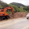 Huy động máy xúc thu dọn đất sạt lở đảm bảo giao thông tren tuyến Quốc lộ 1A đoạn qua huyện Chi Lăng. (Ảnh: Thái Thuần/TTXVN)