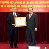 Phó Thủ tướng Nguyễn Xuân Phúc dự và trao tặng Huân chương cho ông Sommad Pholsena. (Ảnh: Minh Quyết/TTXVN)