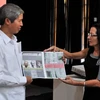 Tổng thư ký OSPAAL Lourdes Cervantes Vasquez (phải) trao tặng một poster về quan hệ song phương cho Đại sứ Việt Nam Dương Minh. (Ảnh: Lê Hà/TTXVN)