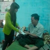 Bà Bùi Thị Quỳnh Vân trao tiền hỗ trợ cho ngư dân Lộc. (Ảnh: Sỹ Thắng/Vietnam+)