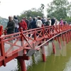 Du khách quốc tế tham quan đền Ngọc Sơn, Hồ Gươm. (Ảnh: Thanh Hà/TTXVN) 