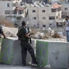 Cảnh sát Israel bắt một người Palestine vạch áo lên để kiểm tra. (Nguồn: AP)
