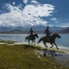 Hai người đàn ông cưỡi ngựa bên hồ Karakol ở Tân Cương, Trung Quốc. (Nguồn: NatGeo)