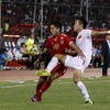 Hậu vệ Quế Ngọc Hải (phải) nỗ lực phá bóng của cầu thủ Myanmar Than Paing trong trận đấu. (Nguồn: EPA/TTXVN)