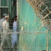 Binh sỹ Mỹ chuyển một tù nhân tại nhà tù Vịnh Guantanamo. (Nguồn: AFP/TTXVN)