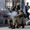 Binh sỹ Israel bắn đạn cao su và hơi cay vào người biểu tình bạo động Palestine ở thành phố Bethlehem, Khu Bờ Tây ngày 18/12/2015. (Nguồn: AFP/TTXVN)