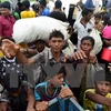Người Hồi giáo Rohingya từ Myanmar chờ nhận hàng cứu trợ tại thị trấn Teknaf, Bangladesh ngày 12/9. (Nguồn: AFP/TTXVN)