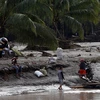 Người dân di chuyển bằng bè để qua sông sau bão Tembin tại tỉnh Lanao del Norte, Philippines ngày 23/12. (Nguồn: THX/TTXVN)