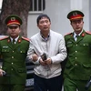 Cảnh sát dẫn giải bị cáo Trịnh Xuân Thanh, nguyên Chủ tịch Hội đồng quản trị, Tổng giám đốc Tổng Công ty Cổ phần Xây lắp dầu khí Việt Nam - PVC đến tòa. (Ảnh: Doãn Tấn/TTXVN)