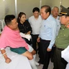 Phó Thủ tướng Thường trực Chính phủ Trương Hoà Bình thăm hỏi, động viên Đại úy Trần Tuấn Thanh bị thương trong khi làm nhiệm vụ đang được điều trị tại Bệnh viện Chợ Rẫy. (Ảnh: Thanh Vũ/TTXVN)