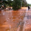 Sự cố vỡ bờ moong tại mỏ titan Suối Nhum khiến đất đỏ và bùn chảy tràn qua đường. (Nguồn ảnh: TTXVN)