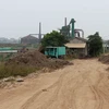 Bùn thải chất từng đống ở trên triền đê sông Hồng, thuộc địa bàn xã Đại Mạch, huyện Đông Anh. (Ảnh: MM/Vietnam+)