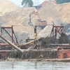 Lợi dụng “tấm bùa” nạo vét, doanh nghiệp đã ngang nhiên sử dụng tàu hút cát công suất lớn để “rút ruột” lòng sông Hồng. (Ảnh: PV/Vietnam+)