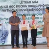 Ông Nguyễn Hoàng Hiệp, Thứ trưởng Bộ Nông nghiệp và Phát triển nông thôn, cùng Hoa hậu Việt Nam 2018 Trần Tiểu Vy trao giải cho các em học sinh giành giải đặc biệt. (Ảnh: UNDP)