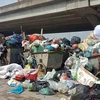 Nhiều tuyến đường ở nội thành Hà Nội ngập ngụa rác thải do người dân chặn xe vào bãi rác Nam Sơn. (Ảnh: Hùng Võ/Vietnam+)