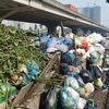 Một điểm tập kết rác tạm thời trên đường Nguyễn Xiển trong những ngày đầu tháng Bảy, khi bãi rác lớn nhất thành phố ở Sóc Sơn đang bị "thất thủ". (Ảnh: P.V/Vietnam+)