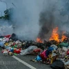 Lượng rác thải quá nhiều, bốc mùi hôi thối, không được thu gom kịp thời, người dân đã đốt để giảm tải. (Ảnh: P.V/Vietnam+)