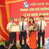 Nhà báo Thuận Hữu, Chủ tịch Hội Nhà báo Việt Nam (thứ 2 bên trái) trao tặng Huân chương Lao động hạng Nhì cho Trung tâm Bồi dưỡng nghiệp vụ báo chí. (Ảnh: H.V/Vietnam+)