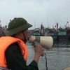 Lực lượng chức năng kêu gọi các ngư dân vào bờ. (Ảnh: Duy Hùng/Vietnam+)