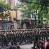 Người dân náo nức khi đoàn diễu binh, diễu hành đi qua tuyến đường. (Ảnh: Nhóm PV/Vietnam+)