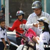 Phụ huynh mua mũ bảo hiểm chuẩn cho trẻ khi tham gia giao thông. (Ảnh: PV/Vietnam+)