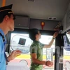 Thanh tra giao thông kiểm tra thiết bị hộp đen được lắp đặt trên xe khách. (Ảnh: Việt Hùng/Vietnam+)