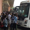 Rất đông hành khách tập trung trước xe khách để lên xe về quê. (Ảnh: Việt Hùng/Vietnam+)