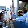 Lái xe cố tình chậm chạp trả từng đồng tiền lẻ tại trạm thu phí BOT số 1 quốc lộ 5 huyện Văn Lâm. (Ảnh: Phạm Kiên/TTXVN)