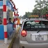 Chủ phương tiện mua vé đường bộ tại trạm thu phí Quốc lộ 6 đoạn Xuân Mai-Hòa Bình. (Ảnh: Việt Hùng/Vietnam+)