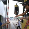 Lái xe dùng tiền mệnh giá 200-500 đồng mua vé qua trạm thu phí BOT tuyến tránh Biên Hòa gây ùn tắc kéo dài. (Ảnh: Sỹ Tuyên/TTXVN)