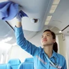 Nữ nhân viên Nguyễn Ánh Tuyết cần mẫn với công việc dọn dẹp, vệ sinh máy bay của Vietnam Airlines. (Ảnh: Doãn Đức/Vietnam+)