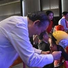 Phó Thủ tướng Chính phủ Trương Hòa Bình trao tặng mũ bảo hiểm cho học sinh lớp Một. (Ảnh: Việt Hùng/Vietnam+)