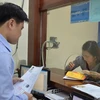 Người dân làm thủ tục cấp giấy phép lái xe. (Ảnh: Việt Hùng/Vietnam+)