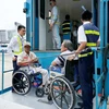 Khi hạ cánh, do phải di chuyển bằng xe lăn nên Vietnam Airlines phải bố trí xe nâng, hạ theo đúng tiêu chuẩn phục vụ người tàn tật. (Ảnh: Anh Tuấn/Vietnam+)