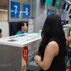 Hành khách mua vé máy bay của Vietnam Airlines. (Ảnh: Việt Hùng/Vietnam+)