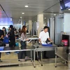 Hành khách làm thủ tục kiểm tra soi chiếu an ninh tại Cảng hàng không. (Ảnh: Việt Hùng/Vietnam+)