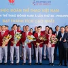 Ông Dương Trí Thành, Tổng giám đốc Vietnam Airlines (áo đen, ngoài cùng bên phải) tặng hoa và chúc mừng Đoàn thể thao Việt Nam gặt hái nhiều thành công tại SEA Games 30. (Ảnh: CTV/Vietnam+)
