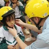 Trẻ em được đội mũ bảo hiểm đạt chuẩn sẽ giảm tỷ lệ chấn thương vùng đầu khi xảy ra tai nạn giao thông. (Ảnh: Việt Hùng/Vietnam+)