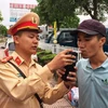 Cảnh sát giao thông tiến hành kiểm tra đo nồng độ cồn đối với lái xe. (Ảnh: Việt Hùng/Vietnam+)